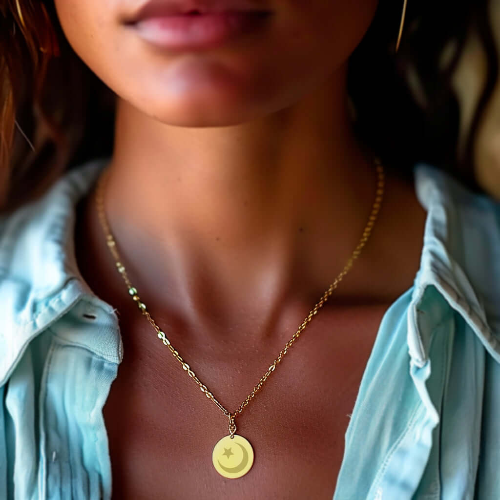 Collier doré avec médaille gravée en forme d'étoile, porté par une femme, ajoutant une touche d'élégance.