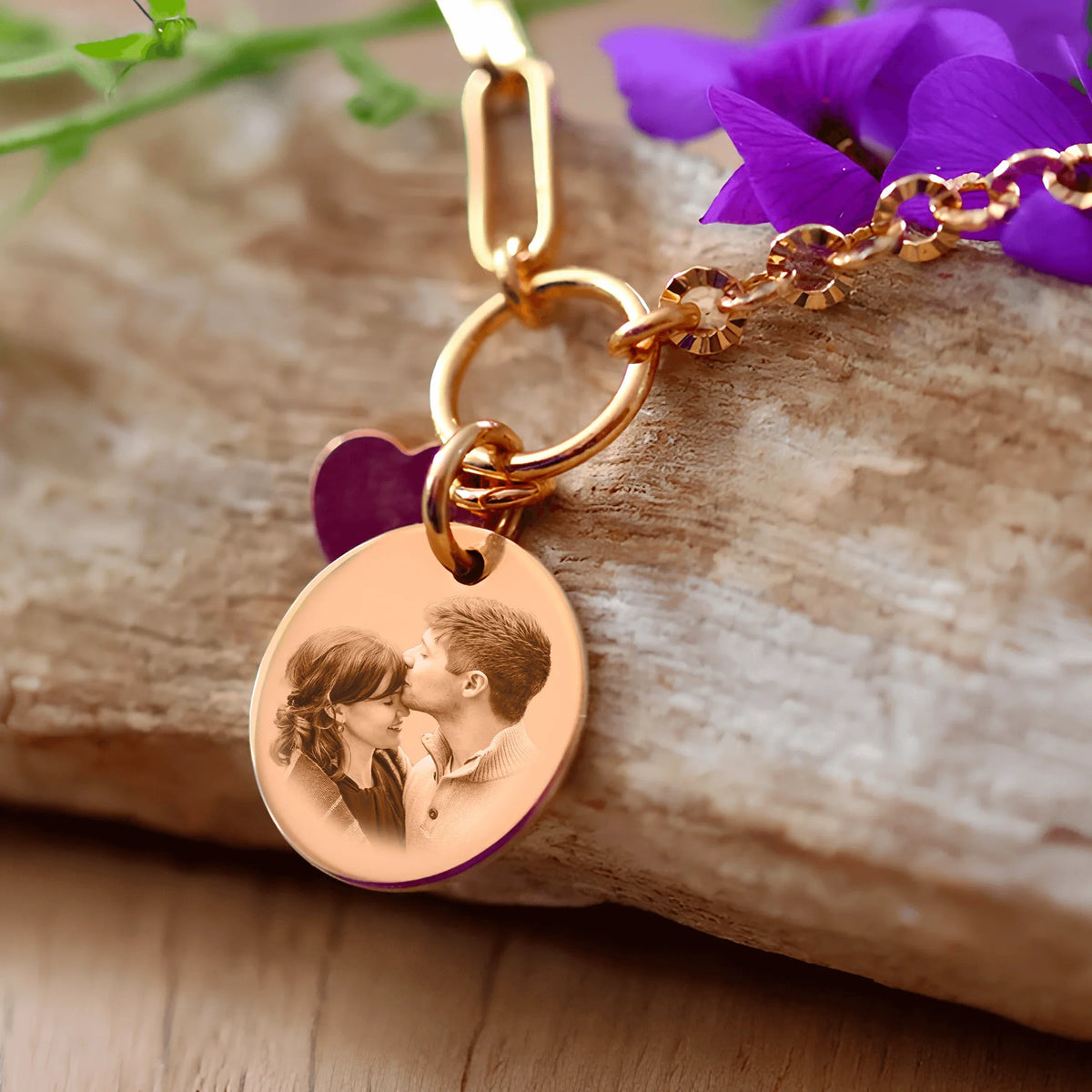 Bracelet rond plaqué or avec cœur gravé et photo d'un couple, symbole de souvenirs précieux.