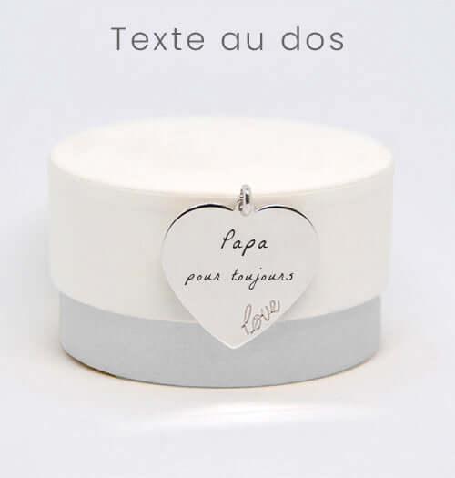 Médaillon cœur en argent GravurePhoto avec texte gravé, posé sur une boîte blanche