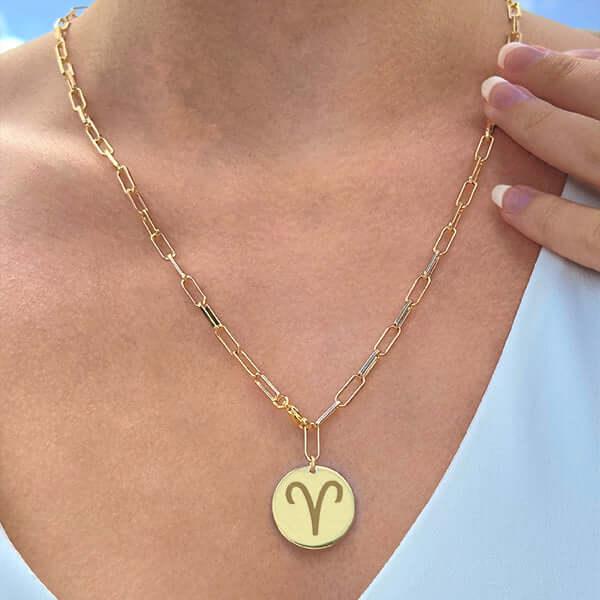 Colgante de corazón de oro personalizado con foto grabada en una cadena de malla plana que se lleva alrededor del cuello.
