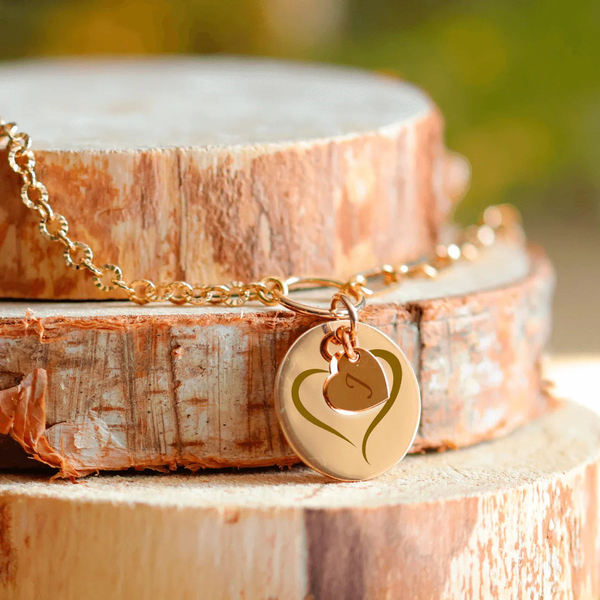 Collier rond plaqué or avec cœur gravé sur base en bois, symbole d'amour et de souvenirs précieux.