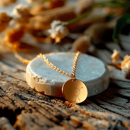 Grand médaillon rond en acier doré avec gravure sur médaillon, posé sur une pierre naturelle.