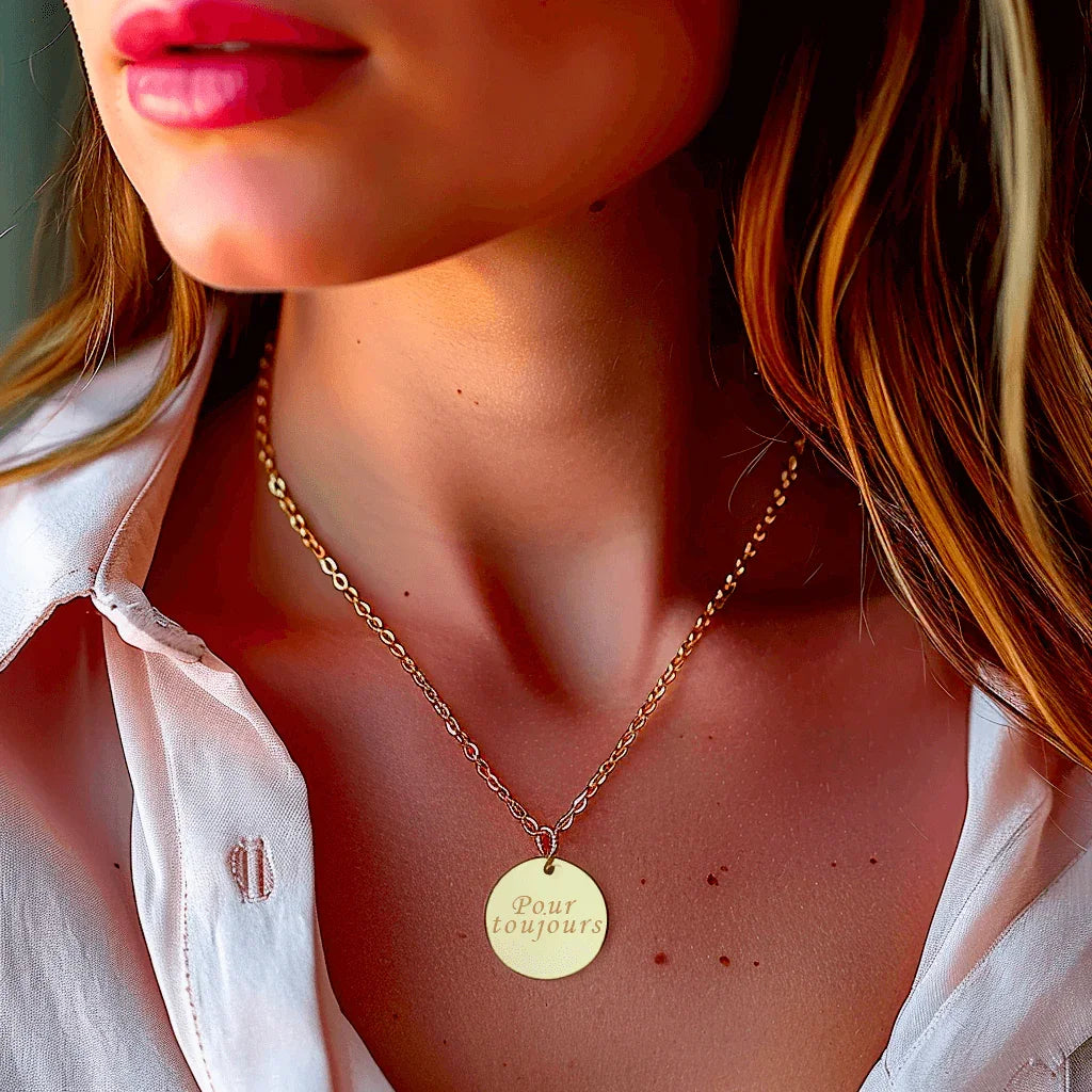 Woman wearing an engraved gold steel pendant with the text 'Forever' on an elegant chain.