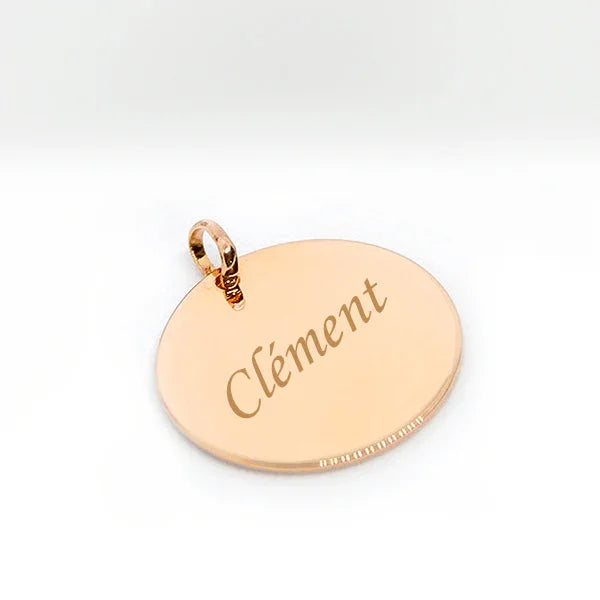 Large round gold-plated pendant engraved with the text 'Clément', elegant finishes.
