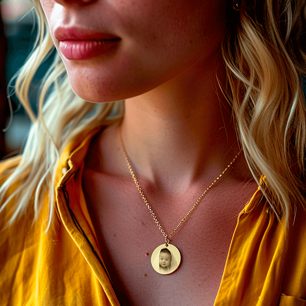 Grand médaillon rond en acier doré avec gravure photo porté par une femme en chemise jaune.