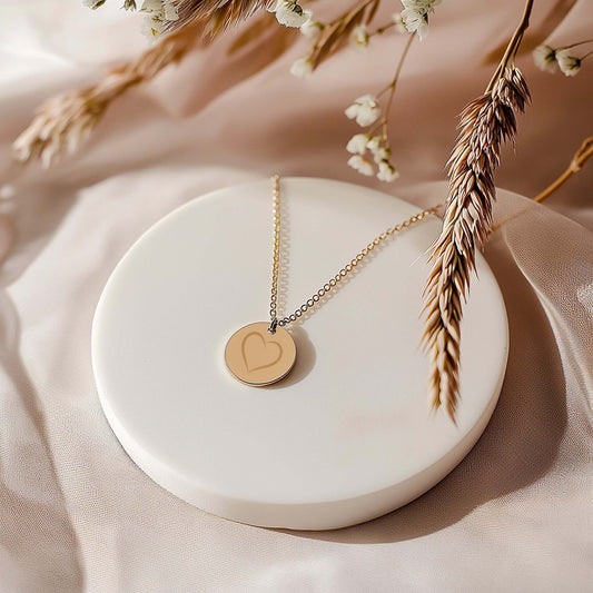 Petit médaillon rond en acier doré avec motif en cœur sur chaîne de 50 cm, élégant et raffiné.