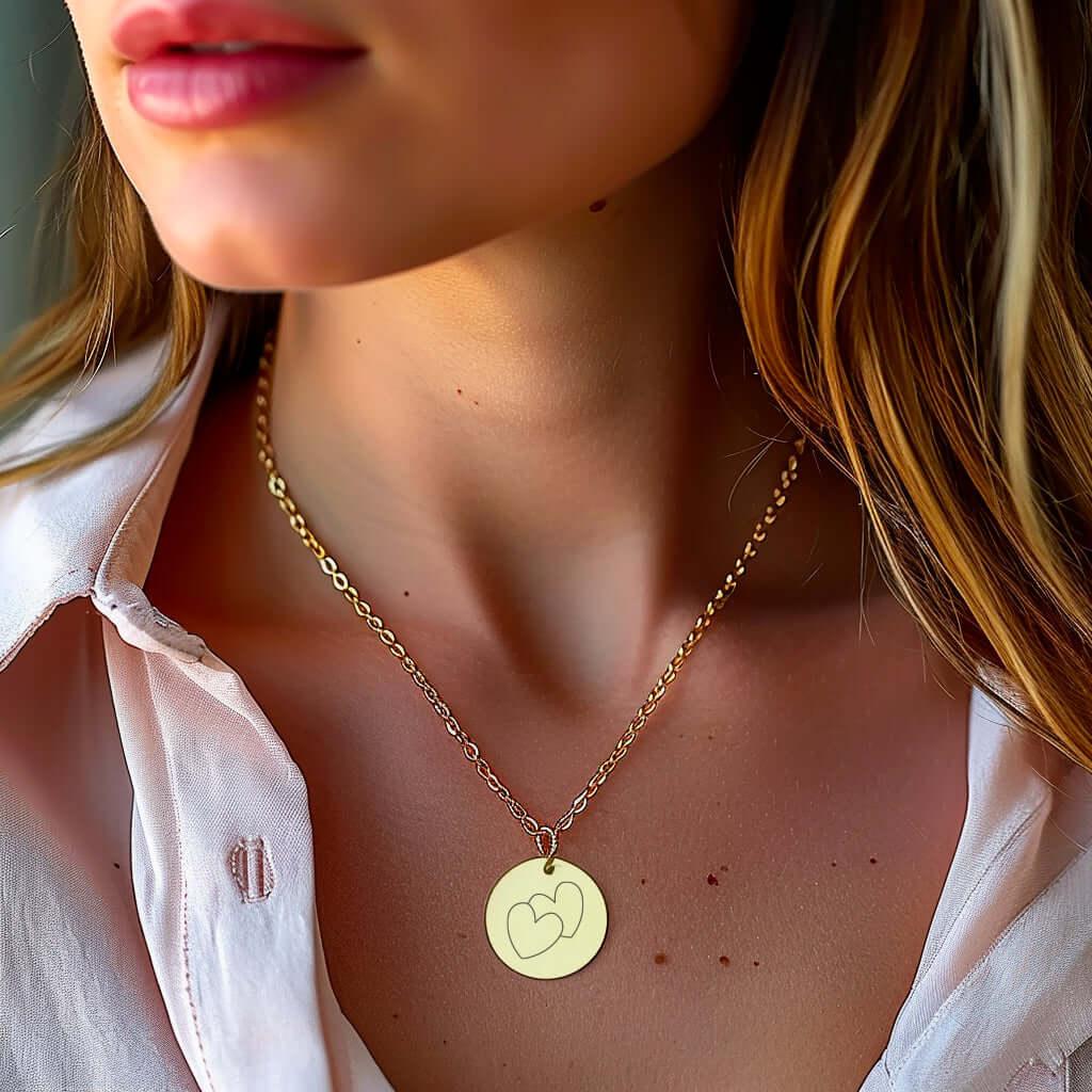 Collar de acero dorado con medallón grabado con motivo de corazón usado por una mujer, elegancia refinada.