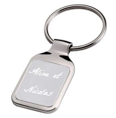 Porte-clés rectangle gravé avec le texte "Aline et Nicolas", idéal pour personnalisation. Dimensions : 4 cm x 2,8 cm.