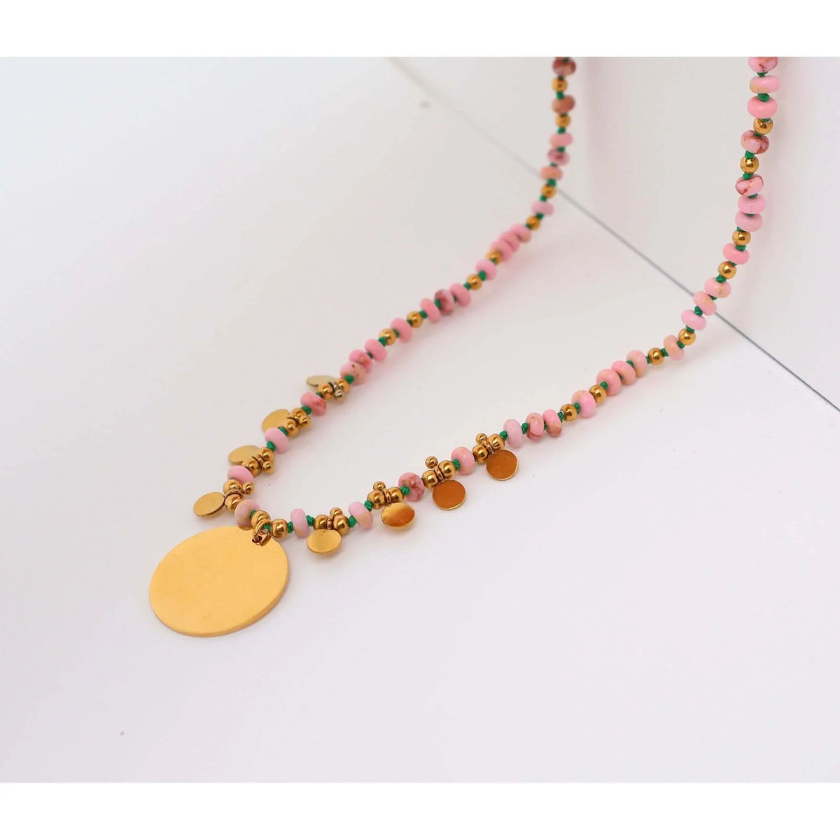 Perlenkette mit personalisiertem Medaillon aus goldfarbenem Edelstahl und zarten rosa Perlen.