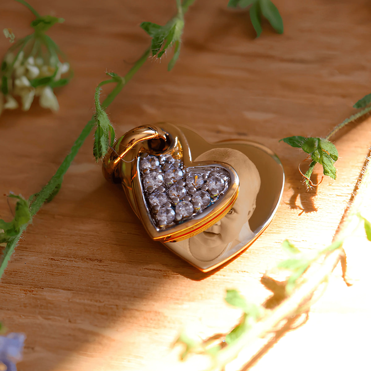 Colgante de corazón bañado en oro grabado con foto y cristales brillantes, símbolo de amor y personalización.