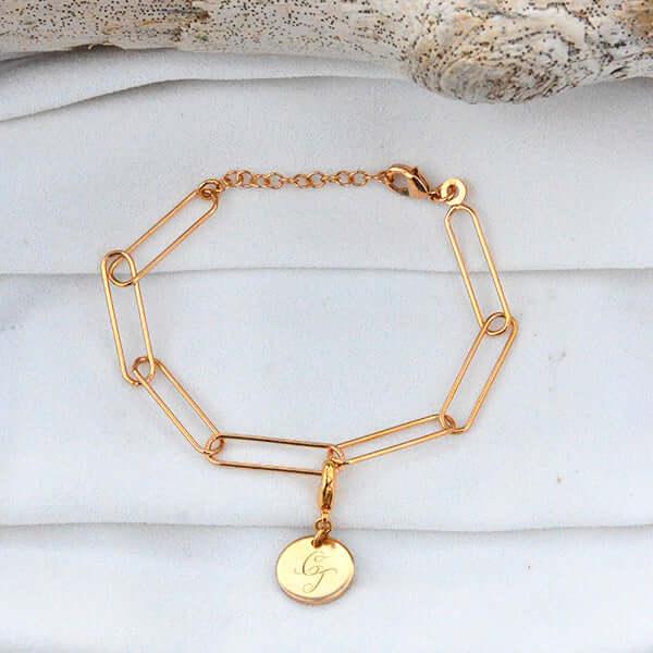 Bracelet mailles plaqué or avec médaille gravée, sur fond blanc
