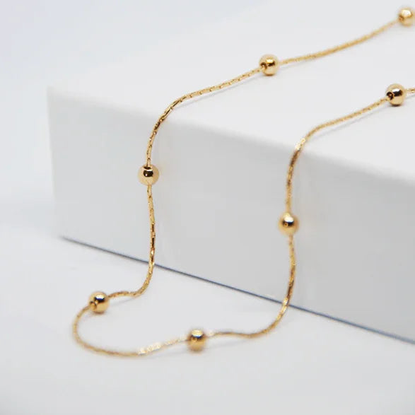 Gold chain with balls, refined jewel EngravingPhoto on white background