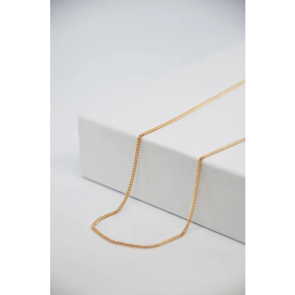 Chaîne gourmette en or, bijou personnalisé GravurePhoto, posée sur boîte blanche