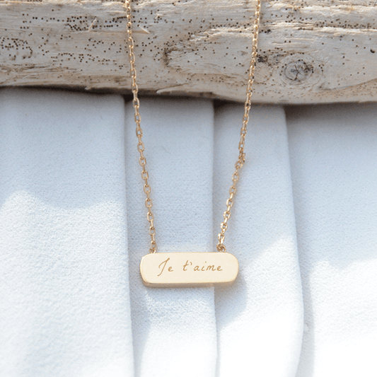 Collier avec un médaillon barre plaqué or gravé avec un texte