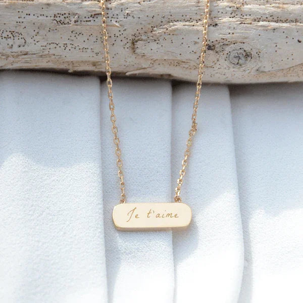 Collier avec un médaillon barre plaqué or gravé avec un texte
