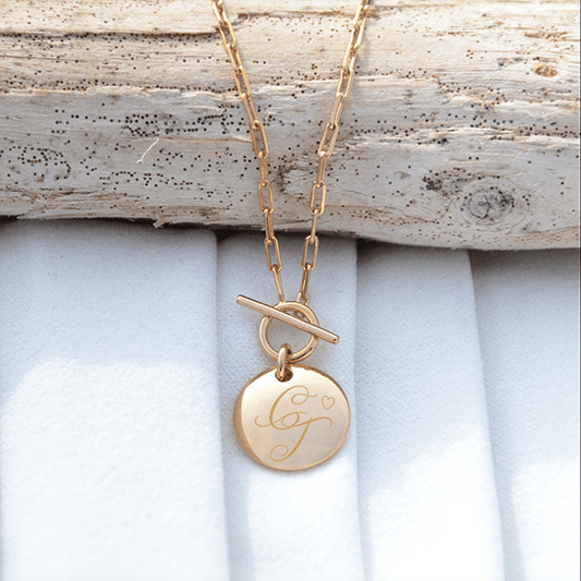 Collier avec un médaillon rond en plaqué or avec une fermeture en T gravé