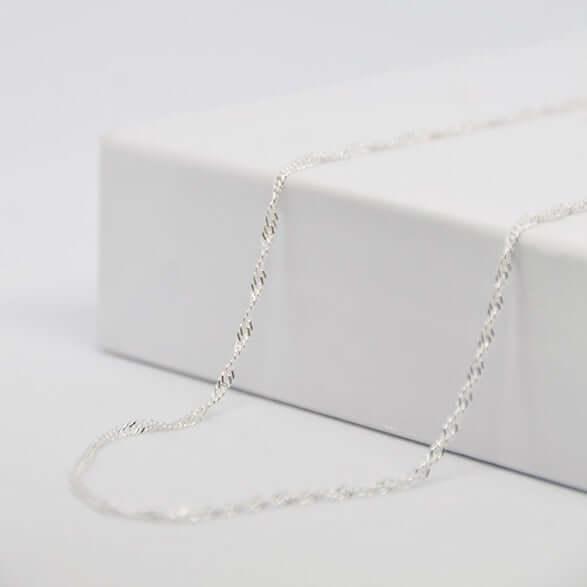 Silver twisted chain on white background, elegant jewelry EngravingPhoto