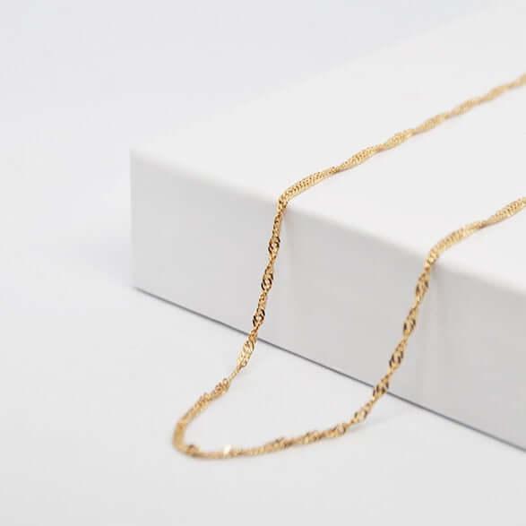 Delicada cadena de oro para colgante de corazón personalizado GravurePhoto, joyería elegante sobre fondo blanco.
