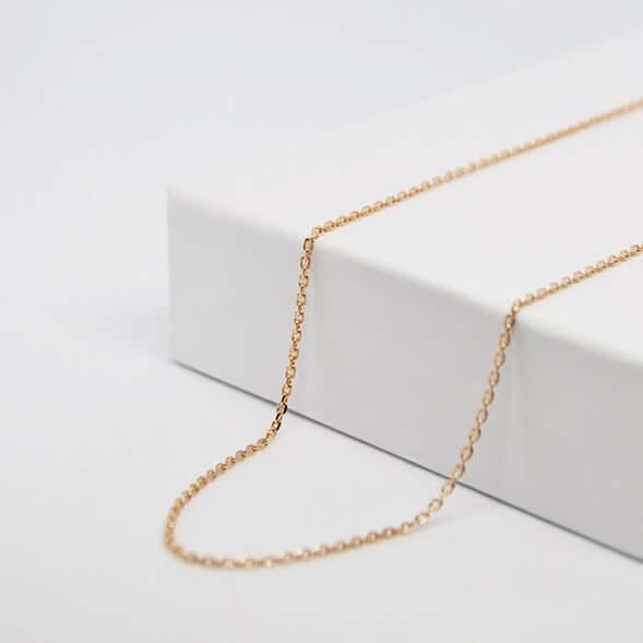 Fina cadena de oro para colgante de corazón personalizado GravurePhoto, colocada sobre una caja blanca