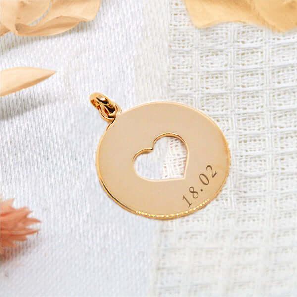 Personalized heart pendant in gold GravurePhoto, engraved with a date, refined jewelry on fabric.