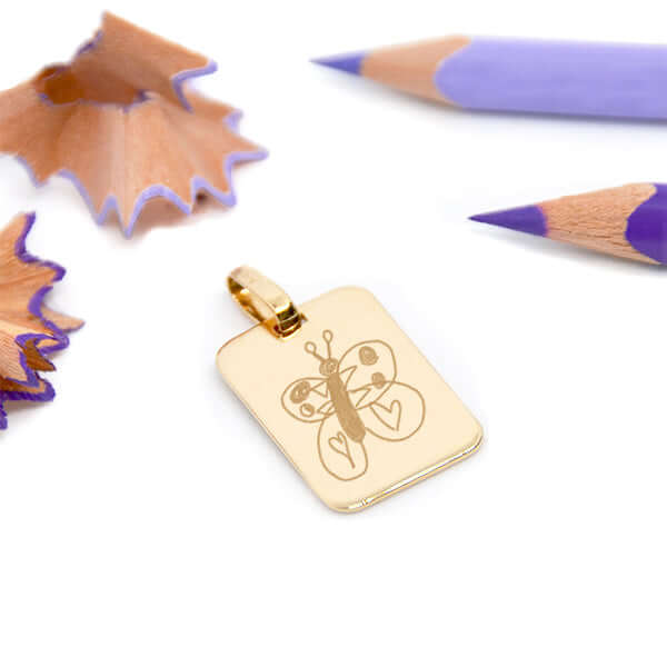 Petit pendentif rectangle en plaqué or gravé avec un dessin enfant en idee cadeau