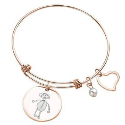 Bracelet avec plaque ronde dorée rose gravée d'un dessin, vue de près