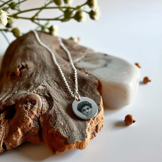 Pendentif cœur personnalisé en or GravurePhoto, posé sur bois avec gravure portrait.