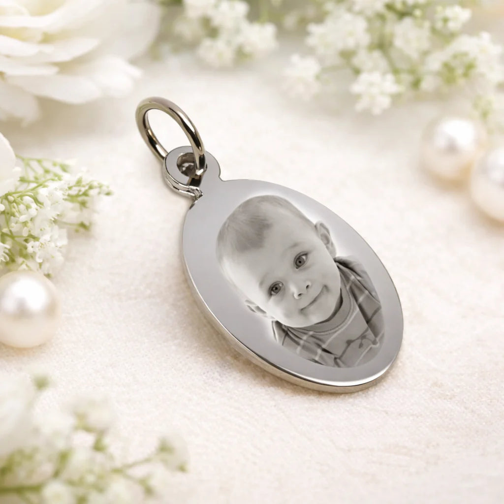 Pendentif ovale en acier inoxydable gravé avec photo personnalisée, dimensions 3x2 cm, livré en pochette cadeau.
