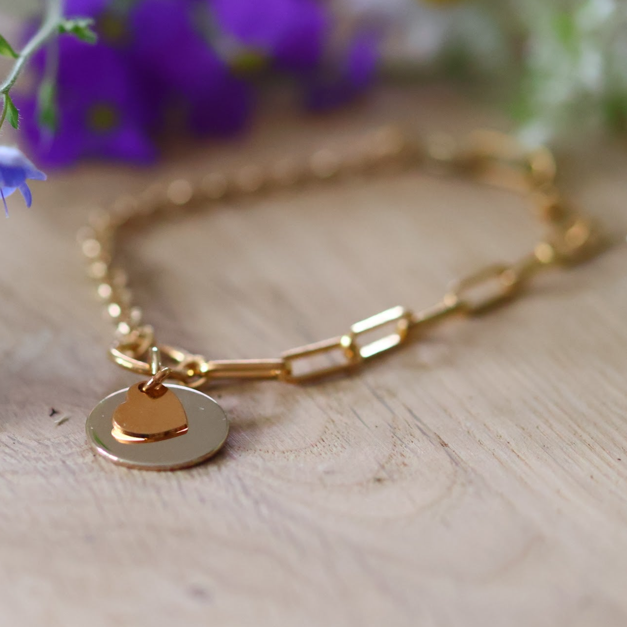 Pulsera redonda bañada en oro con un corazón grabado con un motivo