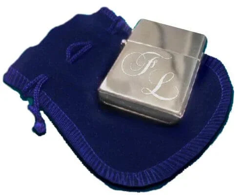 Briquet personnalisé GravurePhoto avec initiales gravées, présenté sur une pochette en velours bleu.