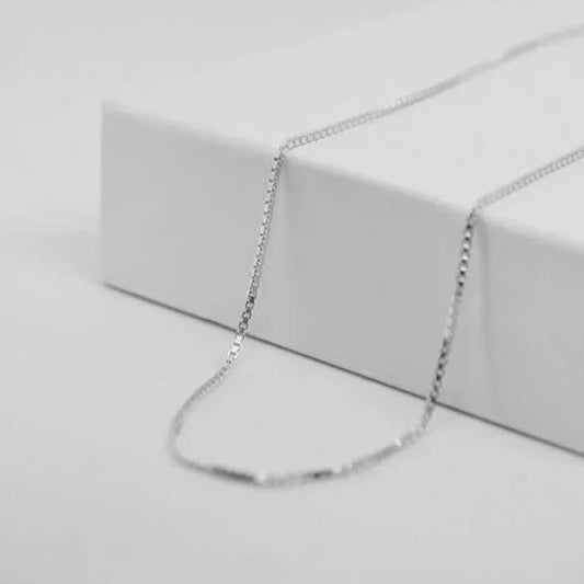 Pendentif cœur personnalisé en or GravurePhoto posé sur une surface blanche élégante